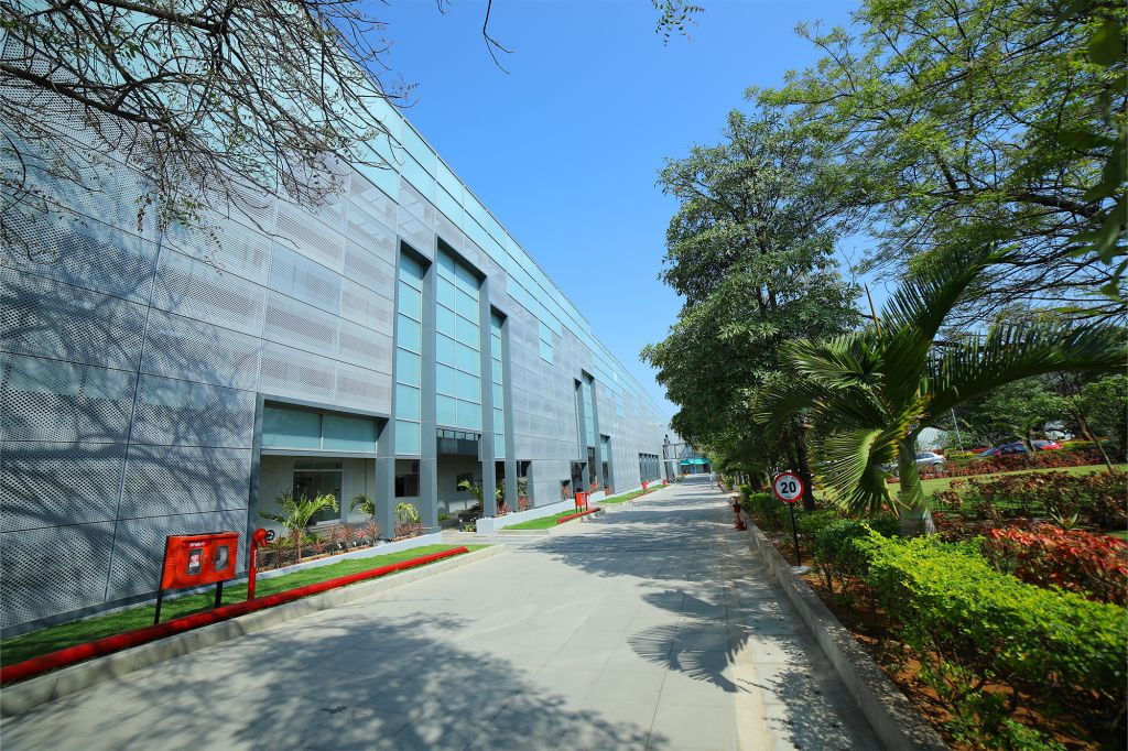 Sai Life Sciences' modern energy-efficient building with a landscaped green walkway, reflecting the company’s commitment to sustainability and environmental responsibility.