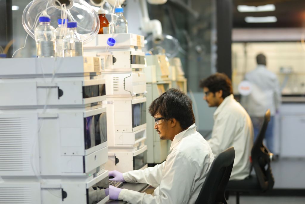 Scientists at Sai Life Sciences' Hyderabad Integrated Campus conducting analytical development using advanced chromatography systems for pharmaceutical research and quality control.