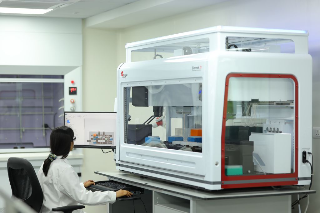 Scientist at Sai Life Sciences' Hyderabad Integrated Campus working with an advanced Biomek i7 automation system for high-throughput DMPK research and drug metabolism studies.